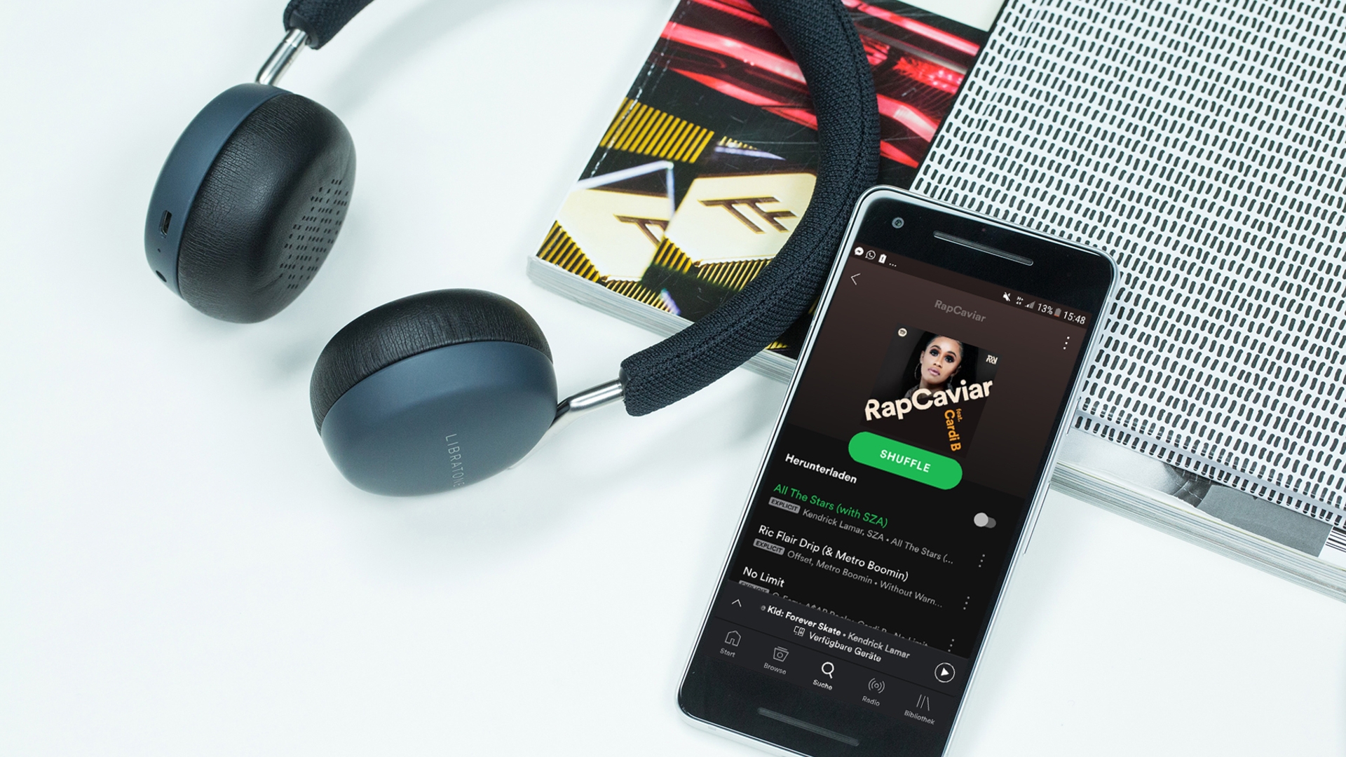 Smartphone mit Spotify App und Kopfhörer auf Tisch