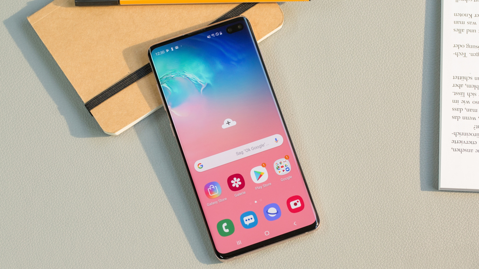 Samsung Galaxy S10 Plus auf Tisch neben einem Notizblock.
