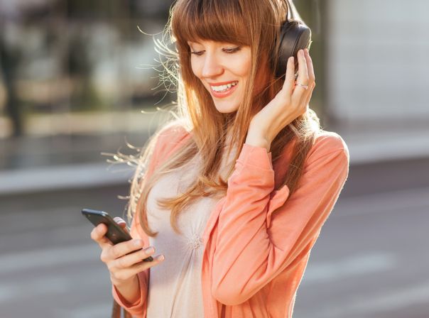 Frau mit Kopfhörer und Smartphone