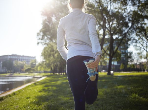 Eine Frau in Laufkleidung dehnt sich