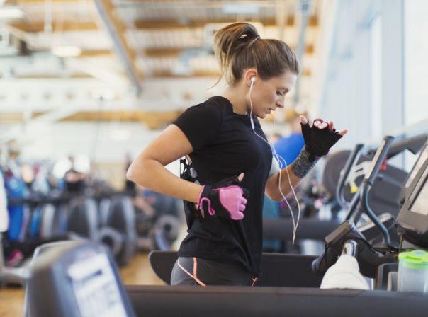 Frau auf Laufband im Fitnessstudio