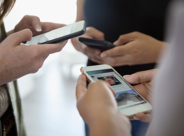 3 Freunde schauen auf ihr Smartphone