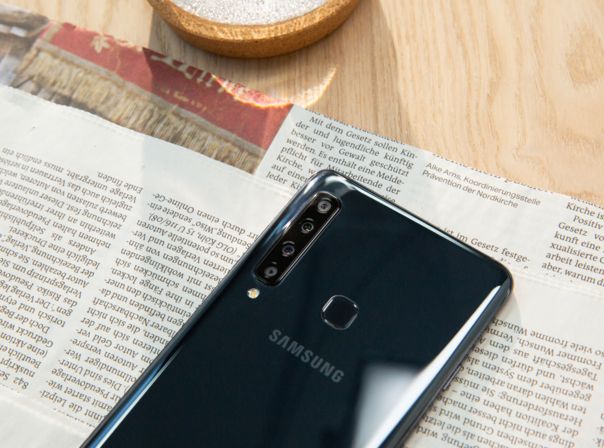 Das Samsung Galaxy A9 (2018) liegt auf dem Tisch auf einer Zeitung.