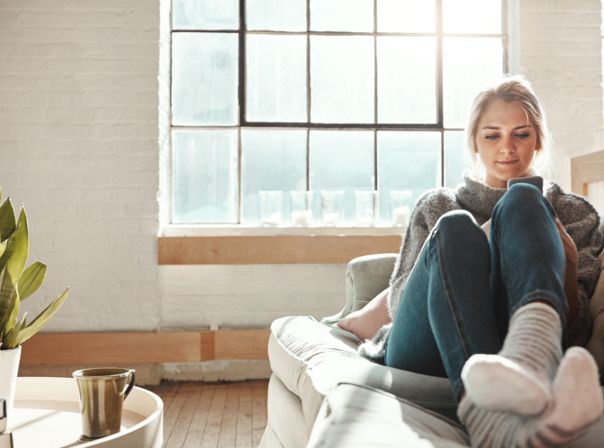 Frau mit Handy auf der Couch