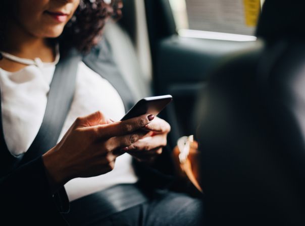 Frau im Auto mit Smartphone