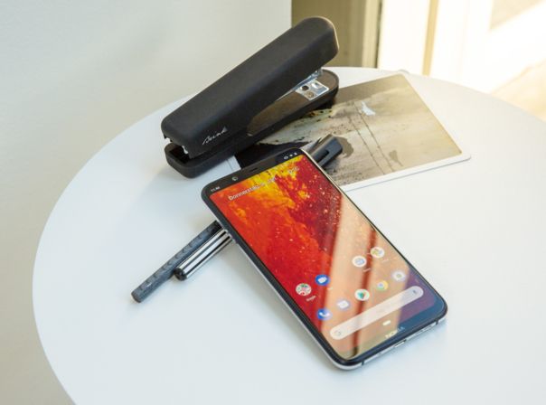 Das Nokia 8.1 auf einem Schreibtisch neben einem Tacker.