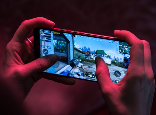 Zwei Hände halten ein Smartphone auf dem ein Spiel läuft.