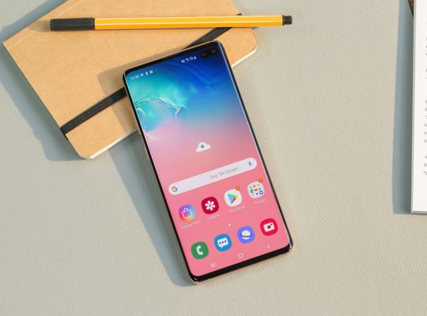 Samsung Galaxy S10 Plus auf Tisch neben einem Notizblock.