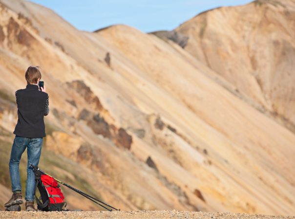 Mensch mit Outdoor-Handy auf Wanderung in den Bergen