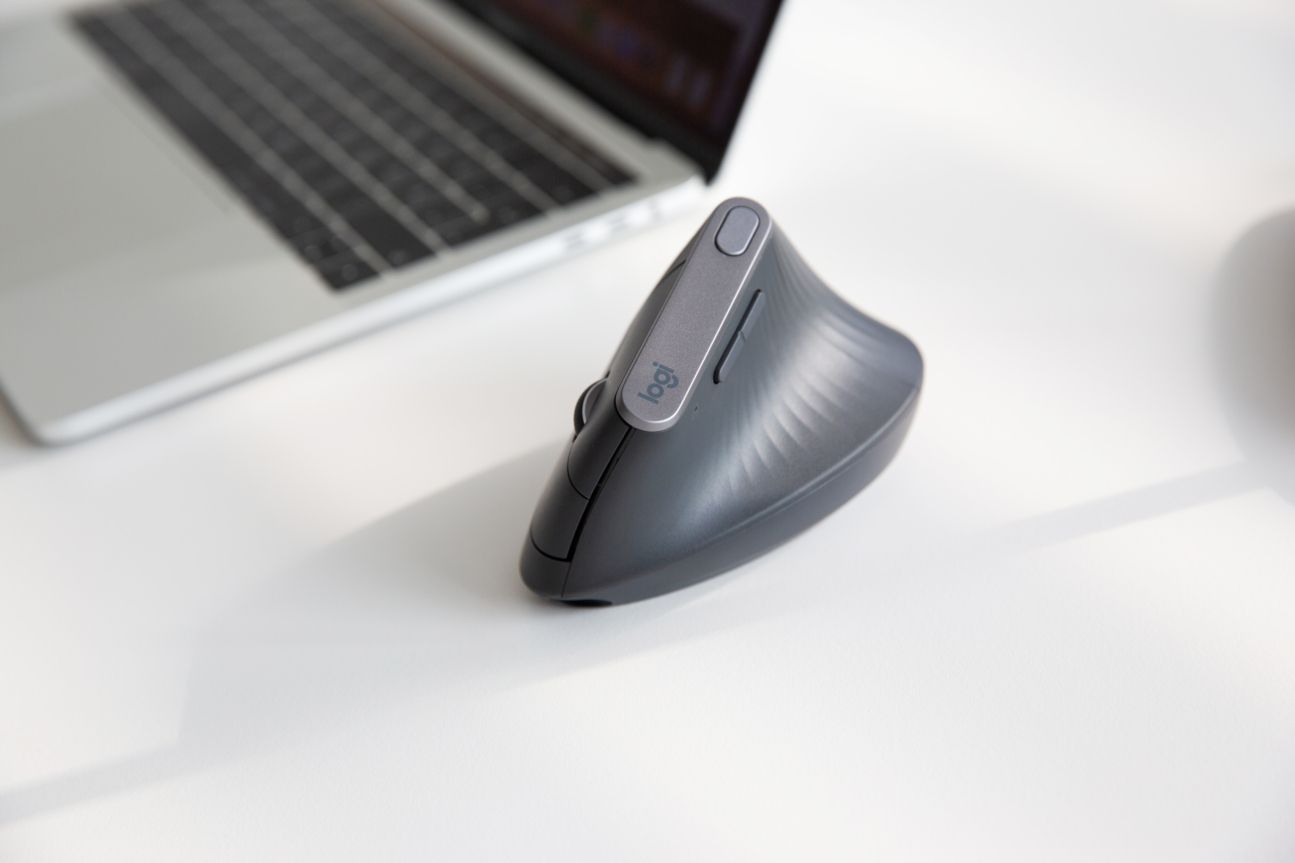 Logitech MX Vertical auf einem Schreibtisch ein MacBook Pro.