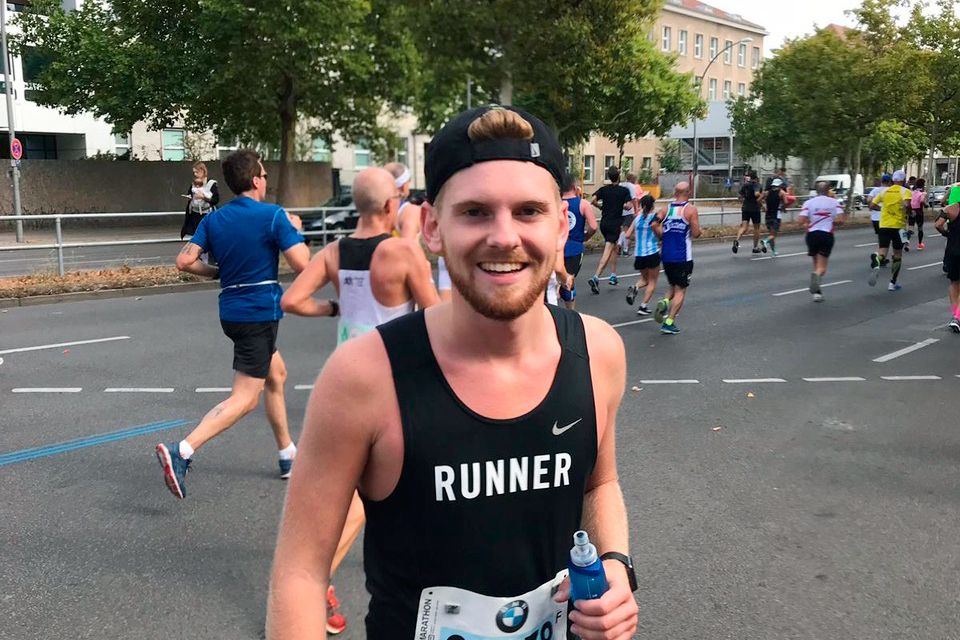 Lars Sonnemann macht eine Trinkpause beim großen Lauf und grinst in die Kamera.