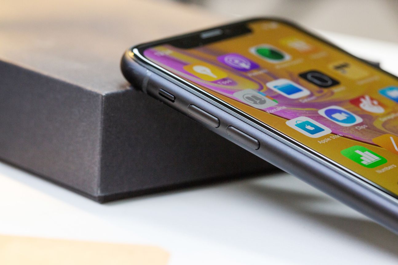 Das iPhone XR, angelehnt an einen Holzstapel.