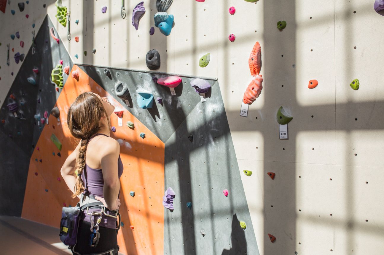 Frau steht vor Boulder-Wand