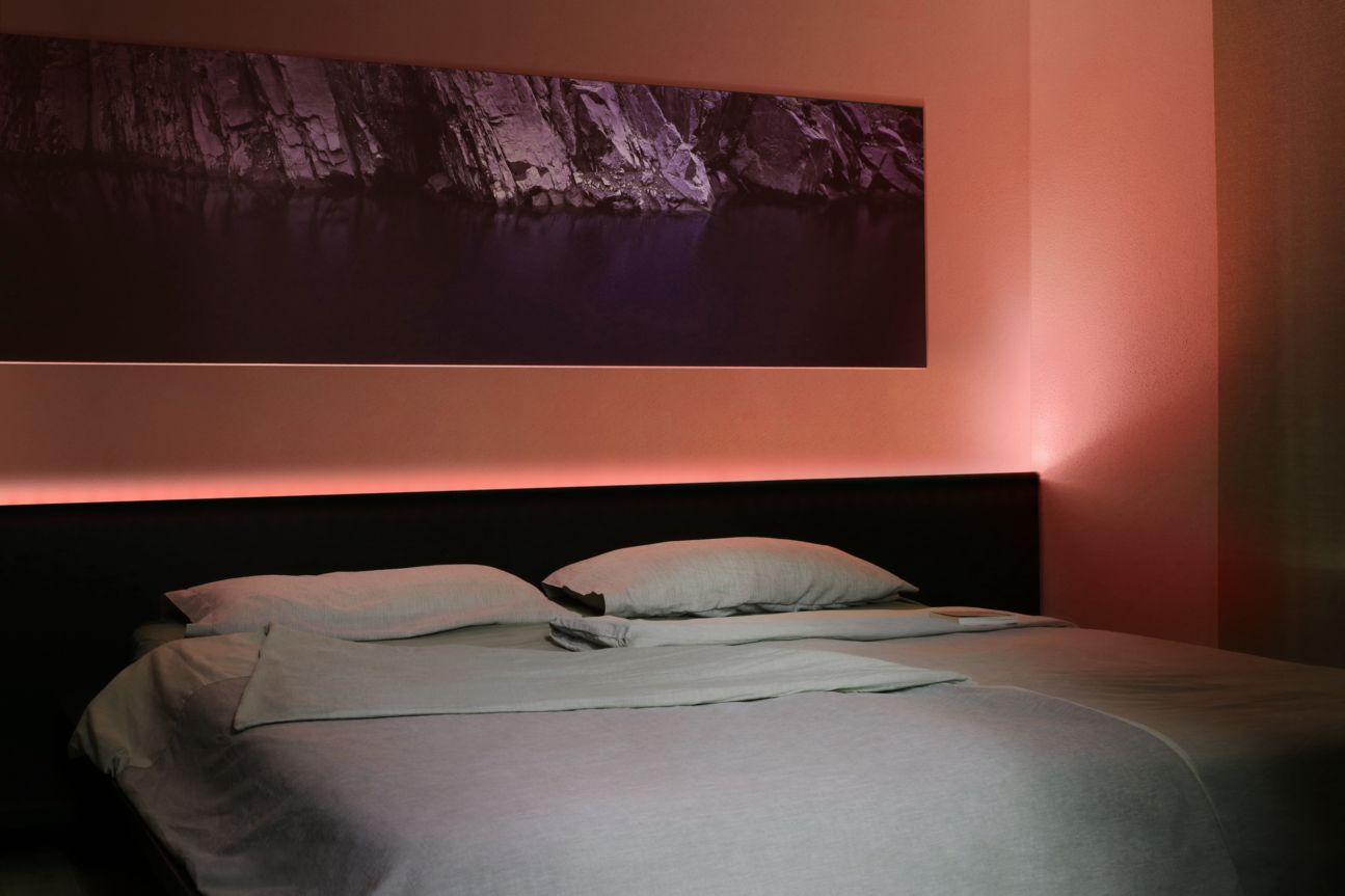 Eve Light Strip leuchtet hinter dem Bett in Koralle