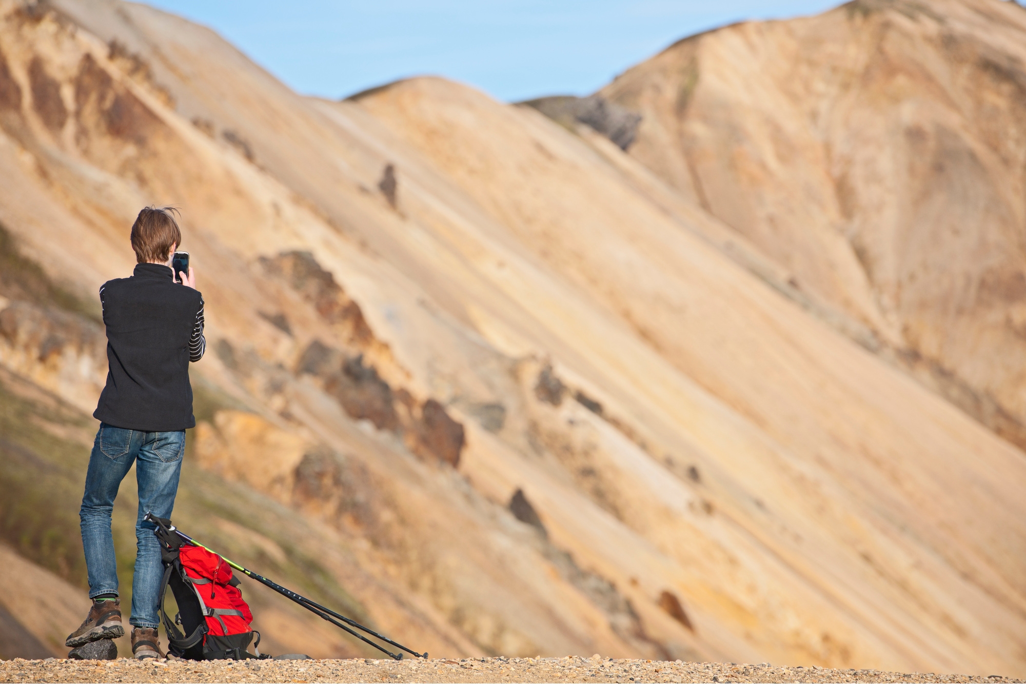 Mensch mit Outdoor-Handy auf Wanderung in den Bergen